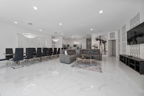 Eine moderne Hotellobby mit einer Sitzecke, einem Sofa, einem Couchtisch und einem Fernseher an der Wand.