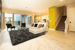 Ein modernes Wohnzimmer mit einem weißen Sofa, einem schwarzen Teppich und einer Treppe.