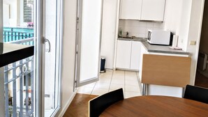 Eine moderne Küche mit weißen Schränken, einer Mikrowelle und einem kleinen Fenster.