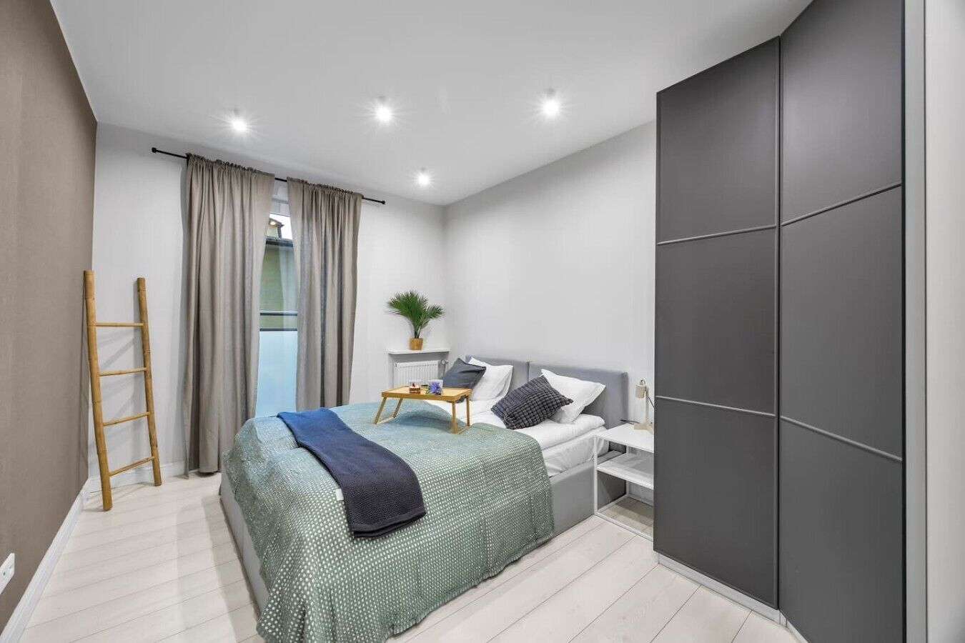 Ein modernes Schlafzimmer mit einem Bett, einem Nachttisch und einem großen Kleiderschrank.