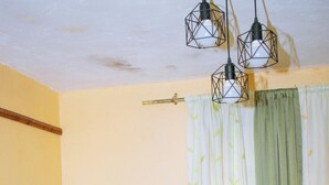 Uma cama com cabeceira, cobertor e controle remoto.