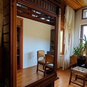 A room with a wooden-framed window, two chairs, a potted plant, and a bookshelf. - SUNNY PARK FAMILY HOME with Largest Private Yard & Big Balcony Free WiFi & bikes (Velenje)