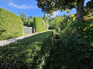 A pathway surrounded by dense greenery and a gated entrance. - SUNNY PARK FAMILY HOME with Largest Private Yard & Big Balcony Free WiFi & bikes (Velenje)