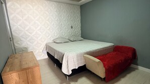 A bedroom with a bed, a wooden nightstand, a red blanket, and a patterned wall. - Rooms for rent in Belém (Belém)