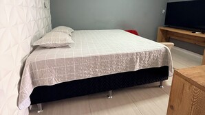 A bedroom with a bed, a TV, and a wooden cabinet. - Rooms for rent in Belém (Belém)
