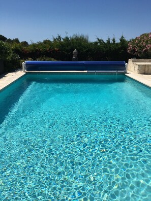 Ein klares, blaues Schwimmbecken mit einer Statue im Hintergrund.
