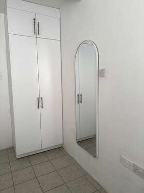 A white wardrobe with two doors and a mirror. - R&R - modern 2 bed 2 bath condo with pool near beaches, grocery and restaurants (Gros Islet)