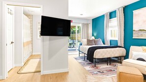 A bedroom with a bed, a TV, a window with curtains, and a view of the outdoors. - 4BR Wellness Retreat Hot Tub, Sauna & Game Room (Nekoosa)