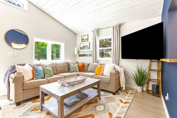 Ein Wohnzimmer mit einer Couch, einem Couchtisch und einem Flachbildfernseher.