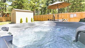 A hot tub with a wooden deck, a small shed, and a wooden fence. - 4BR Wellness Retreat Hot Tub, Sauna & Game Room (Nekoosa)