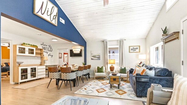 A spacious living area with a dining set, a sofa, and a large wall sign. - 4BR Wellness Retreat Hot Tub, Sauna & Game Room (Nekoosa)