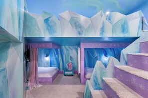 Ein Kinderzimmer mit einem Bett, einem Stuhl und einer Treppe.
