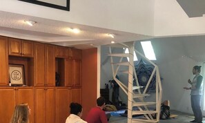 Ein Zimmer mit Holzschränken, einer Leiter und einer stehenden Person.