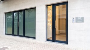 Ein modernes Gebäude mit großen Glasüren und einem Schild mit der Aufschrift 'EREZA SUITES'.