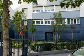 Ein modernes Gebäude mit dunkler Fassade, zahlreichen Fenstern und einem verschlossenen Eingang.