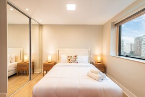 A hotel room with a large bed, bedside tables, a mirror, and a window with a city view. - Studio on Faria Lima With Pool and Spa - Bt1110 (São Paulo)