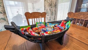Ein Esstisch mit einem Korbstuhl, gefüllt mit verschiedenen Snacks.