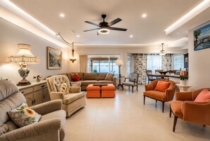 A spacious living room with a sectional sofa, ottomans, and a dining area with a table and chairs. - 3BR Vegas Home Jacuzzi Suite • BBQ • Pet Friendly (Las Vegas)