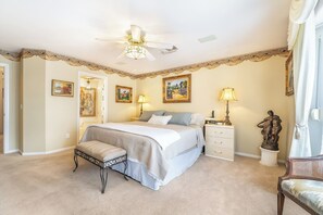 A bedroom with a bed, bedside tables, a bench, a ceiling fan, and artwork on the walls. - 3BR Vegas Home Jacuzzi Suite • BBQ • Pet Friendly (Las Vegas)