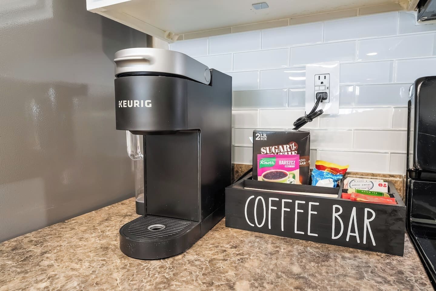 A KEURIG coffee maker and a coffee bar with various coffee products.