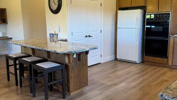 Une cuisine dotée d’un îlot central, de meubles en bois, d’un réfrigérateur et d’un four.