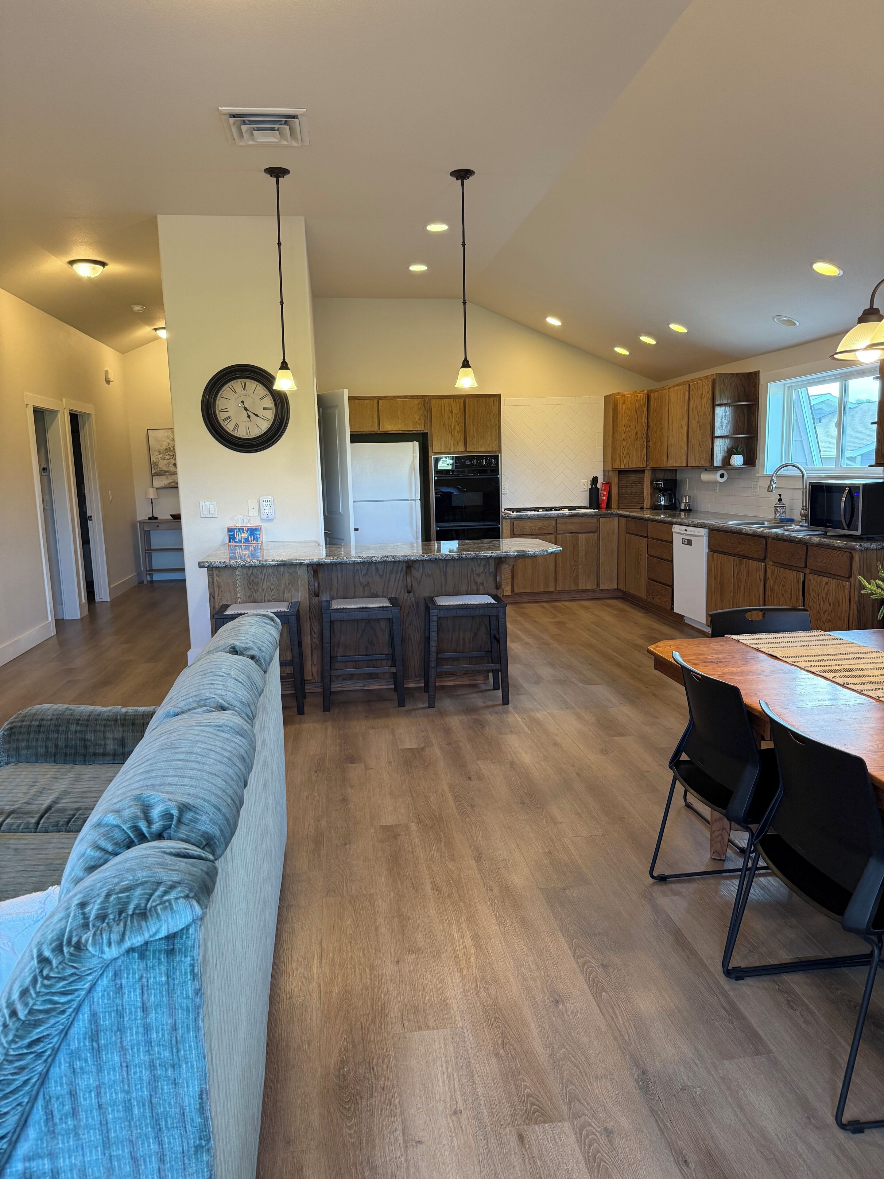 Une cuisine moderne avec des meubles en bois, un îlot central et un coin repas comprenant une table et des chaises.