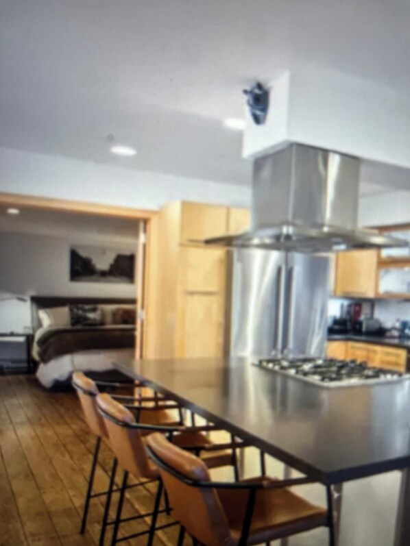 A modern kitchen with a central island, bar stools, and a built-in oven. - Gorgeous 2-bedroom condo charming Stillwater overlooking St. Croix River (Stillwater)