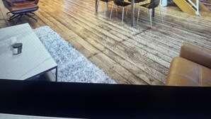 A spacious loft with a kitchen, dining area, and a staircase leading to an upper level.