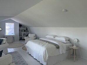 Un dormitorio con una cama, una silla, un escritorio y una estantería.