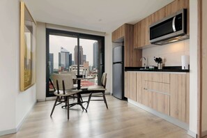 Eine moderne Küche mit großem Fenster, Holzschränken und Blick auf die Stadtlandschaft.
