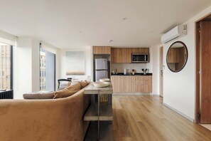 Eine moderne Küche mit Holzausstattung, einer integrierten Mikrowelle und einem großen Fenster.