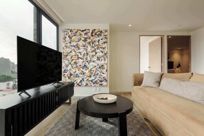 A modern living room with a large TV, a colorful abstract painting, a sofa, and a small table with a bowl. - w* | Modern 2BR in Cuauhtemoc (Ciudad de México)