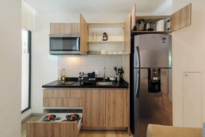 Cafetera o tetera, frigorífico, microondas y placa de cocina