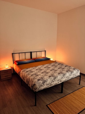 A bedroom with a bed, bedside tables, and a nightstand. - Vrbo Property (Staranzano)