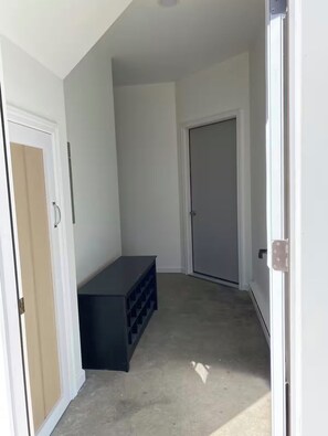 A hallway with a door, a black storage unit, and a carpeted floor. - Tranquil studio with AC in charming Pulaski perfect for getaway (Pulaski)
