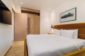 A hotel room with a bed, a wooden wardrobe, a bedside table with a lamp, and a framed picture on the wall. - w* | Warm 2BR  w/ AC in the Heart of Cuauhtémoc (Ciudad de México)