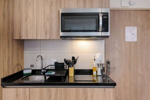 Cafetera o tetera, frigorífico, microondas y placa de cocina