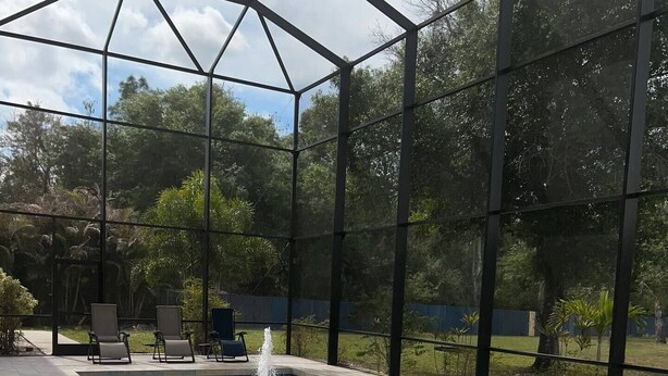 Ein Schwimmbecken mit einer Springbrunnenanlage, umgeben von einer überdachten Terrasse mit Sitzgelegenheiten.