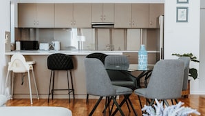 Eine moderne Küche mit Essbereich, einem weißen Sofa und einem Couchtisch mit einer Vase.