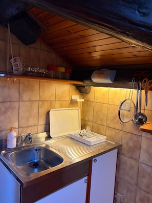 A kitchen with a sink, a countertop, and various kitchen utensils. - The Old Town Attic (Senigallia)