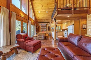 A spacious living room with a large brown leather sofa, a red leather sofa, and a wooden coffee table. - Straight From The Heart (Lyle)