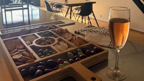 A wooden serving tray with assorted snacks and a glass of champagne on a table. - Stylish New York-Style Loft in Parnell  Spacious Auckland Escape with parking. (parnell)
