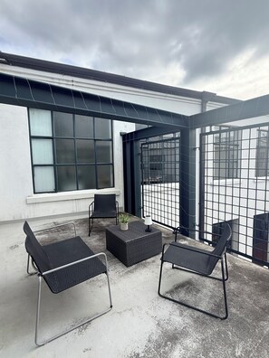 An outdoor patio with two chairs, a small table, and a potted plant. - Stylish New York-Style Loft in Parnell  Spacious Auckland Escape with parking. (parnell)