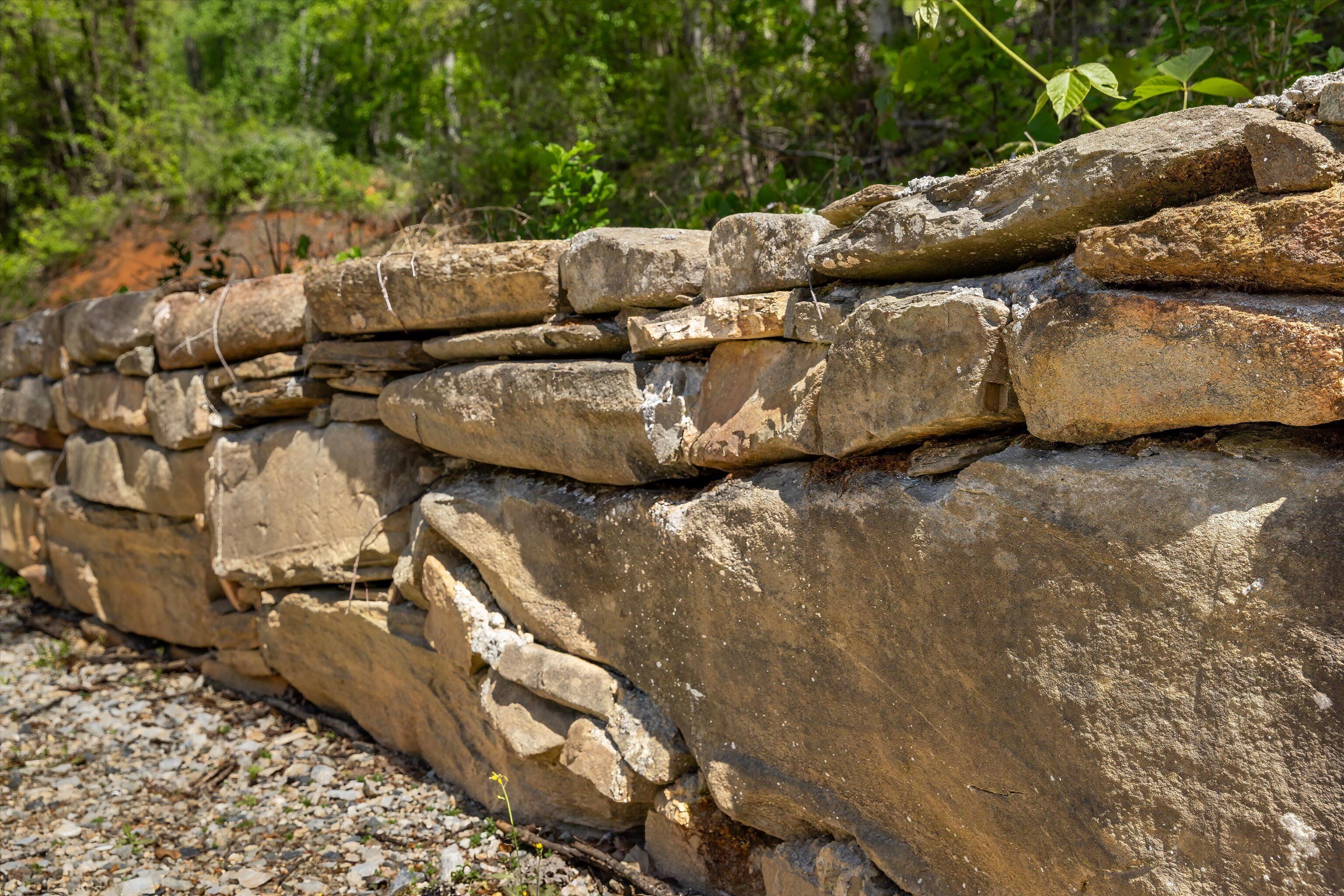 Un muro de piedra con piedras de formas irregulares apiladas horizontalmente.