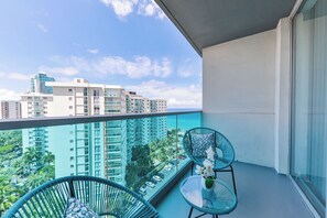 A balcony with two chairs and a table, overlooking a cityscape and the ocean. - Ocean View 1-bedroom apartment with AC in beautiful Hollywood Beach pool, beach (Hollywood)