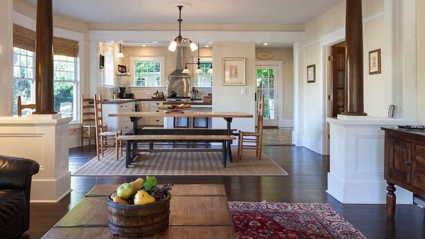 Una cocina amplia con una isla central, muebles de madera y un ventanal grande.