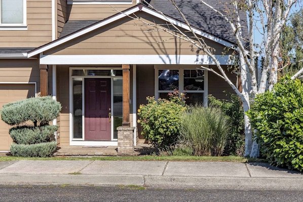 A residential house with a front porch, a red door, and a well-maintained lawn. - West Sail 30 Day Minimum (Hood River)