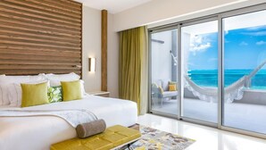 Een moderne hotelkamer met een groot bed, uitzicht op zee en een hangmat op het balkon.