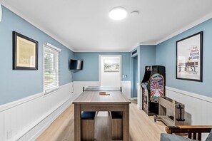 Ein Zimmer mit Tischtennisplatte, Fernseher, gerahmtem Zertifikat und Jukebox.