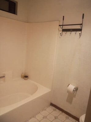 Ein Badezimmer mit Badewanne, Toilette und Handtuchhalter.
